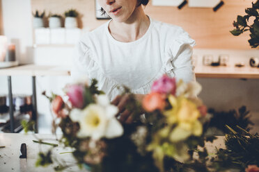 Mittelteil eines Blumenhändlers, der Blumen im Geschäft arrangiert - CAVF25099