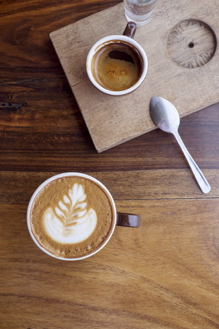 Draufsicht auf Kaffeetassen auf einem Holztisch in einem Cafe, lizenzfreies Stockfoto
