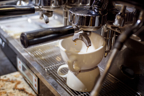 Espressomaschine gießt Kaffee in eine Tasse im Café - CAVF25153