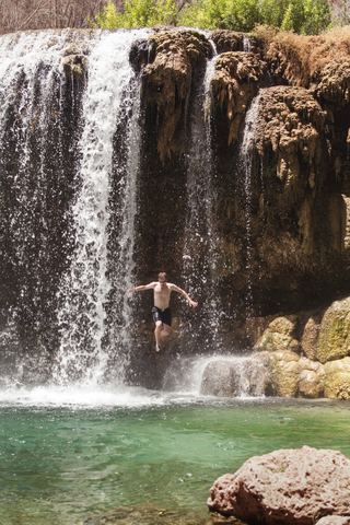 Mann springt von den Havasu-Fällen im Grand Canyon National Park, lizenzfreies Stockfoto