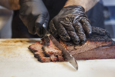 Midsection of chef cutting steak in kitchen - CAVF25194