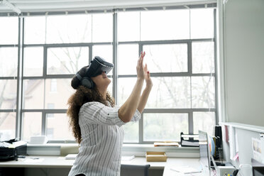 Geschäftsfrau trägt Virtual-Reality-Simulator im Büro - CAVF25248