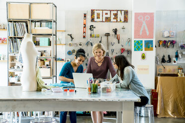 Geschäftsfrauen arbeiten an einem Laptop im Kreativbüro - CAVF25310