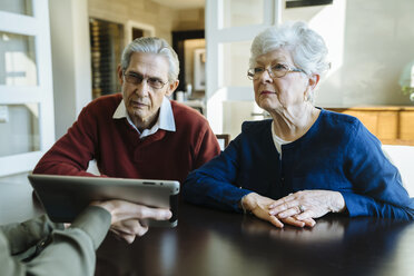 Cropped image of financial advisor explaining plan to senior couple on tablet computer in office - CAVF25357