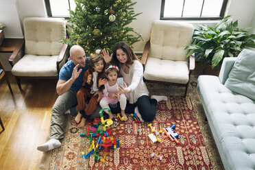 Glückliche Familie bei einer Videokonferenz unter dem Weihnachtsbaum zu Hause - CAVF25436