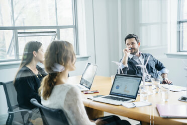 Geschäftsleute diskutieren während einer Besprechung im Büro durch ein Fenster gesehen - CAVF25466