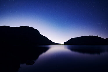 Blick auf den See und die Silhouette der Berge vor blauem Himmel in der Abenddämmerung - CAVF25541