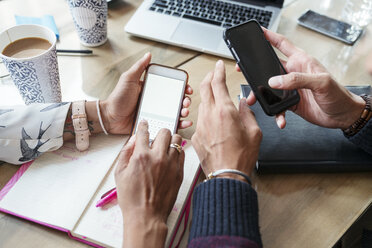 Ausgeschnittenes Bild von Geschäftsleuten, die im Büro Mobiltelefone benutzen - CAVF25594