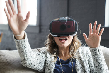 Businesswoman wearing virtual reality simulator in office - CAVF25597