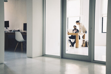 Geschäftsleute diskutieren im Büro durch die Tür gesehen - CAVF25619