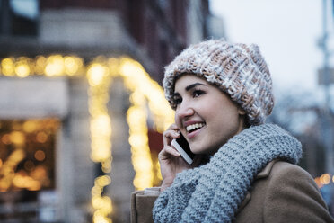 Nahaufnahme einer glücklichen Frau, die mit einem Mobiltelefon spricht - CAVF25650