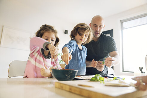 Vater hilft Sohn und Tochter bei der Zubereitung von Essen zu Hause - CAVF25654