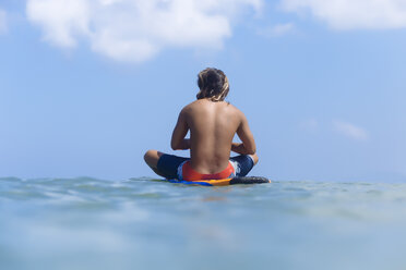 Indonesien, Bali, Surfer auf Surfbrett sitzend - KNTF01102