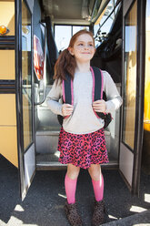 Glückliches Mädchen mit Rucksack an der Bustür - CAVF25927