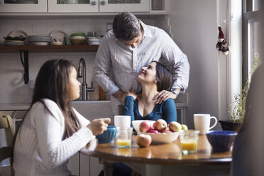 Glückliche Familie beim Frühstück am Tisch in der Küche - CAVF26084