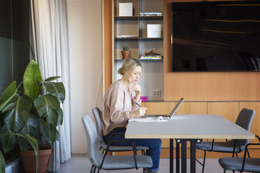 Seitenansicht einer Geschäftsfrau bei der Arbeit am Tisch im Büro - CAVF26119