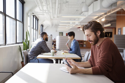 Coworkers working at desks in office - CAVF26122