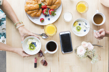 Blick von oben auf Freunde beim Frühstück am Tisch in einem Cafe - CAVF26147