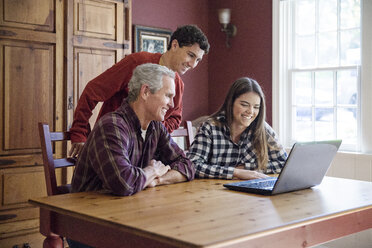 Familie schaut auf den Laptop zu Hause - CAVF26189