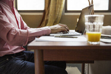 Seitenansicht eines Mannes mit Laptop am Tisch - CAVF26246