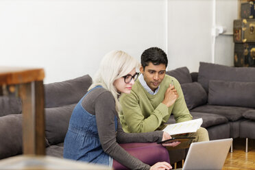 Geschäftsleute benutzen einen Laptop während einer Besprechung im Kreativbüro - CAVF26249