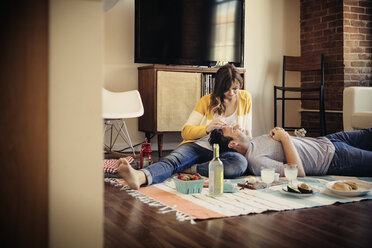 Happy couple relaxing on carpet at home - CAVF26312