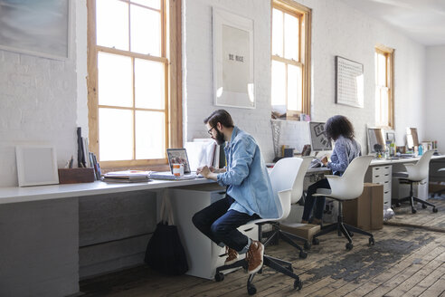 Geschäftsleute arbeiten am Schreibtisch in einem kreativen Büro - CAVF26353