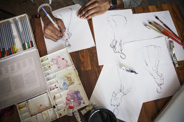 Overhead view of malefaction designer drawing on paper at table - CAVF26369