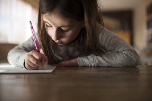 Mädchen schreibt Hausaufgaben zu Hause - CAVF26408
