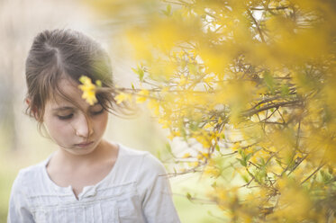 Close-up of girl standing by flowering plant - CAVF26415