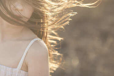 Abgeschnittenes Bild eines Mädchens mit zerzaustem Haar an einem sonnigen Tag - CAVF26427