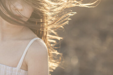 Cropped image of girl with tousled hair during sunny day - CAVF26427