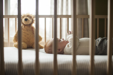 Seitenansicht eines kleinen Jungen in einem Kinderbett liegend - CAVF26457