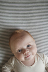 Overhead portrait of baby boy lying on bed - CAVF26459