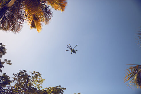 Niedriger Blickwinkel von Hubschrauber fliegen in blauen Himmel - CAVF26566