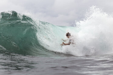 Junger Mann surft auf riesigen Meereswellen - CAVF26696