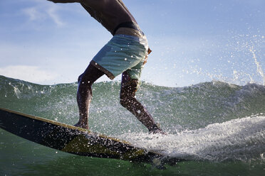 Tiefschnitt eines Mannes beim Surfen auf dem Meer - CAVF26699