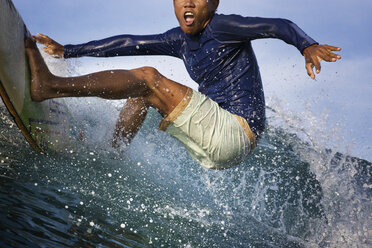 Aufgeregter junger Mann beim Surfen auf dem Meer - CAVF26704