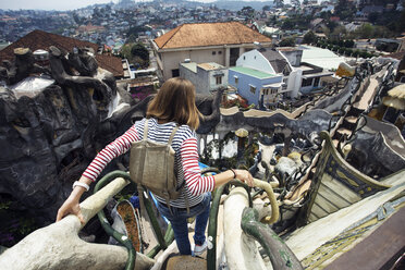 Rear view of woman moving down steps over cityscape - CAVF26715