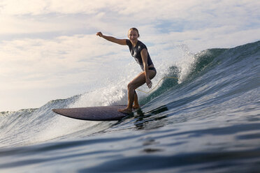 Carefree woman surfboarding on sea - CAVF26719