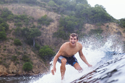 Fröhlicher Mann beim Surfen auf dem Meer - CAVF26733