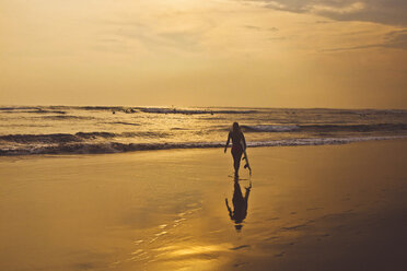 Silhouette woman with surfboard walking at beach - CAVF26765