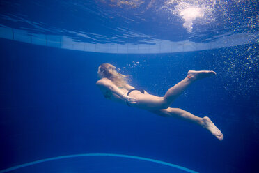 Full length of woman swimming in pool - CAVF26775