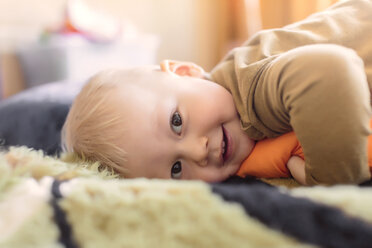 Close-up portrait of boy lying on bed at home - CAVF26805