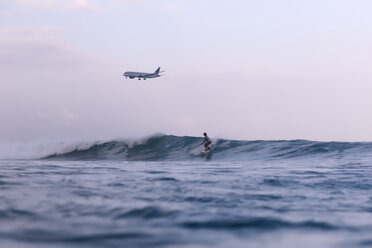 Flugzeug fliegt über Surfer im Meer - CAVF26850