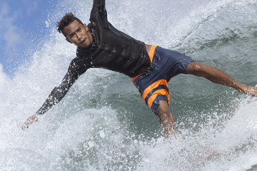 Porträt eines unbekümmerten Mannes beim Surfen auf dem Meer - CAVF26857