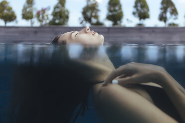 Frau mit geschlossenen Augen schwimmt auf dem Wasser - CAVF26860