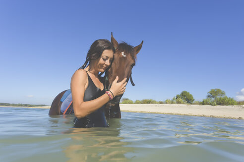 Indonesien, Bali, Frau mit Pferd im Wasser - KNTF01109