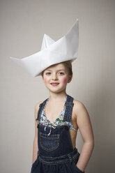 Porträt eines kleinen Mädchens mit großem Papierboot auf dem Kopf - FSF01000