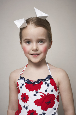 Portrait of little girl with two paper boats on her head stock photo